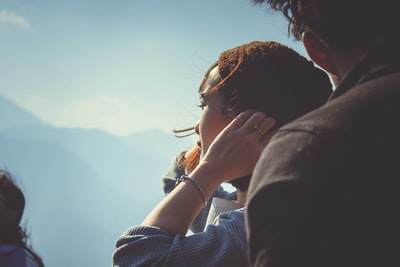 女人在男人手里拿着她的头发在白天
